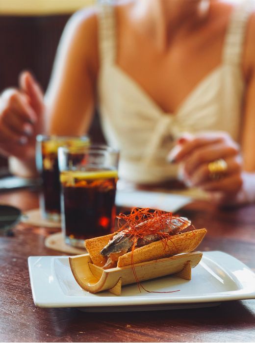 Una mujer de fondo pide una tapa en Sitges